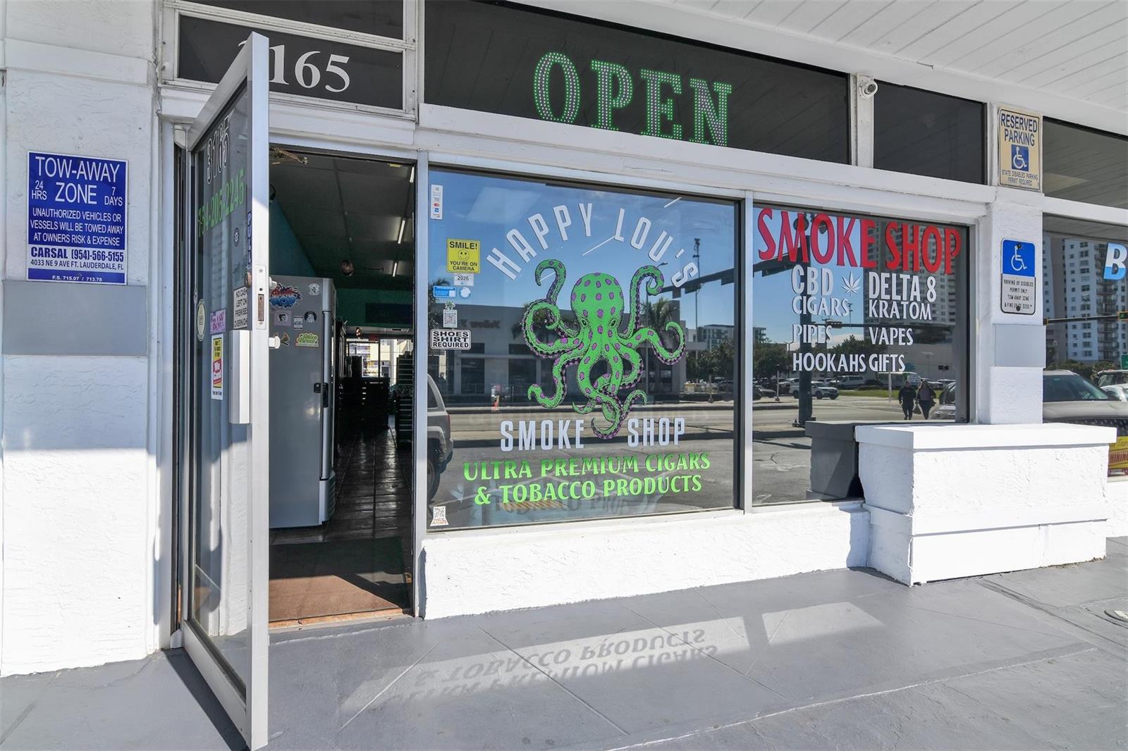 The exterior of a smoke shop features a glass door, large windows, and signage — 3165 E Atlantic Boulevard, Pompano Beach FL 33062, POMPANO BEACH, FL