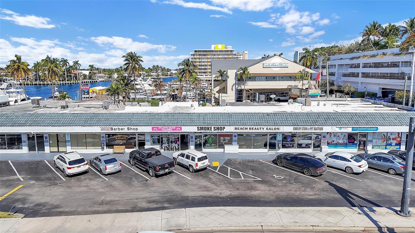 An exterior view of a single-story commercial strip mall with a parking lot in front — 3165 E Atlantic Boulevard, Pompano Beach FL 33062, POMPANO BEACH, FL