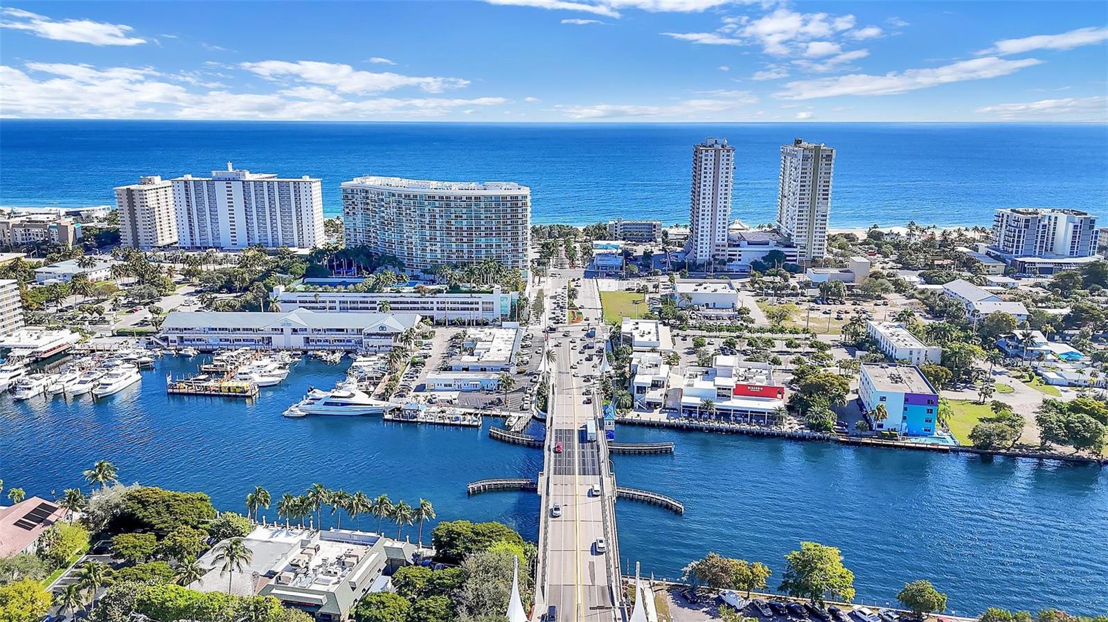An aerial view shows a bridge spanning a waterway lined with boats and coastal buildings — 3165 E Atlantic Boulevard, Pompano Beach FL 33062, POMPANO BEACH, FL