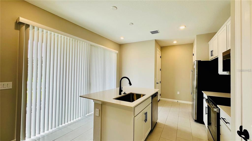 A two-story duplex with beige siding, stone accents, and a front walkway — 1528 ERIN BREEZE LANE, KISSIMMEE, FL