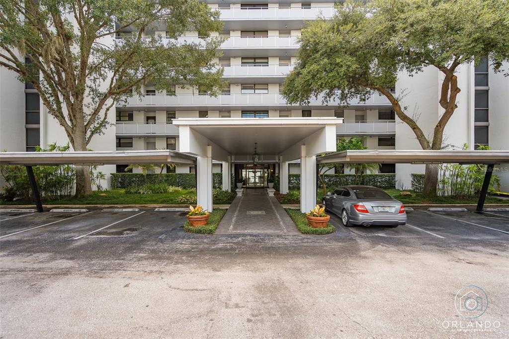 An empty living room features dark hardwood floors, white walls, and a sliding glass door — 1100 S ORLANDO AVENUE UNIT 601, MAITLAND, FL