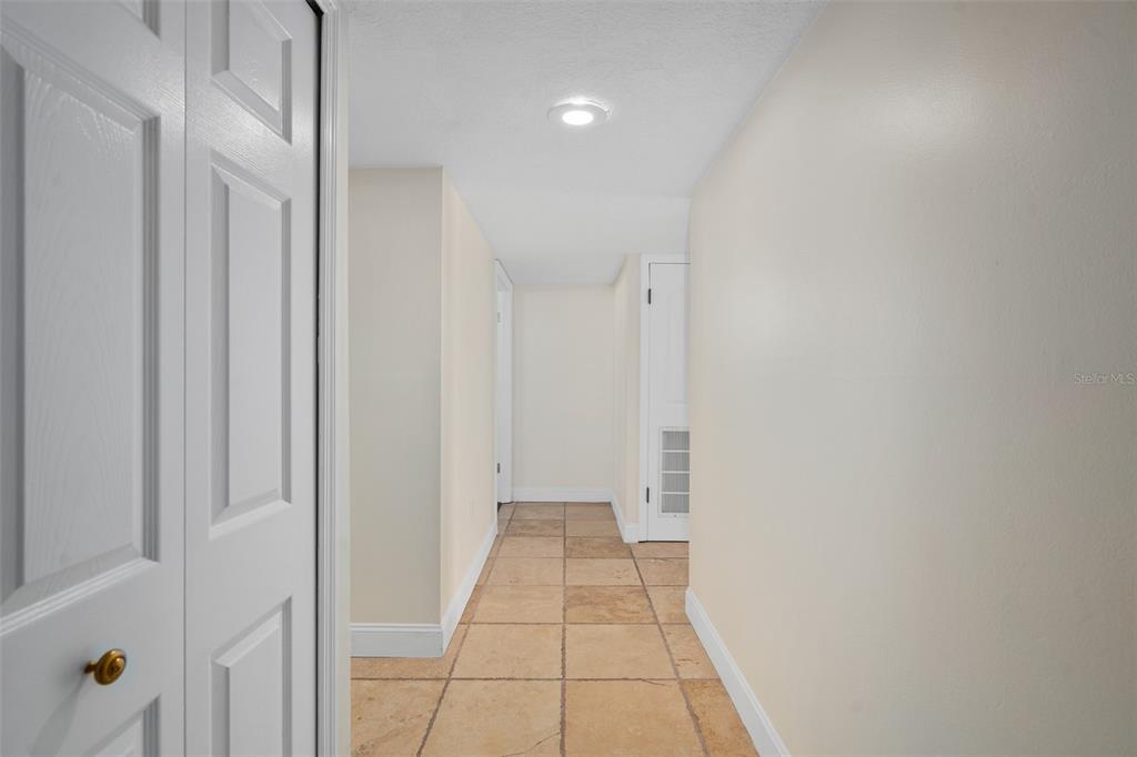 A kitchen features a wooden island with a granite countertop, white cabinets, and pendant lights — 1100 S ORLANDO AVENUE UNIT 601, MAITLAND, FL