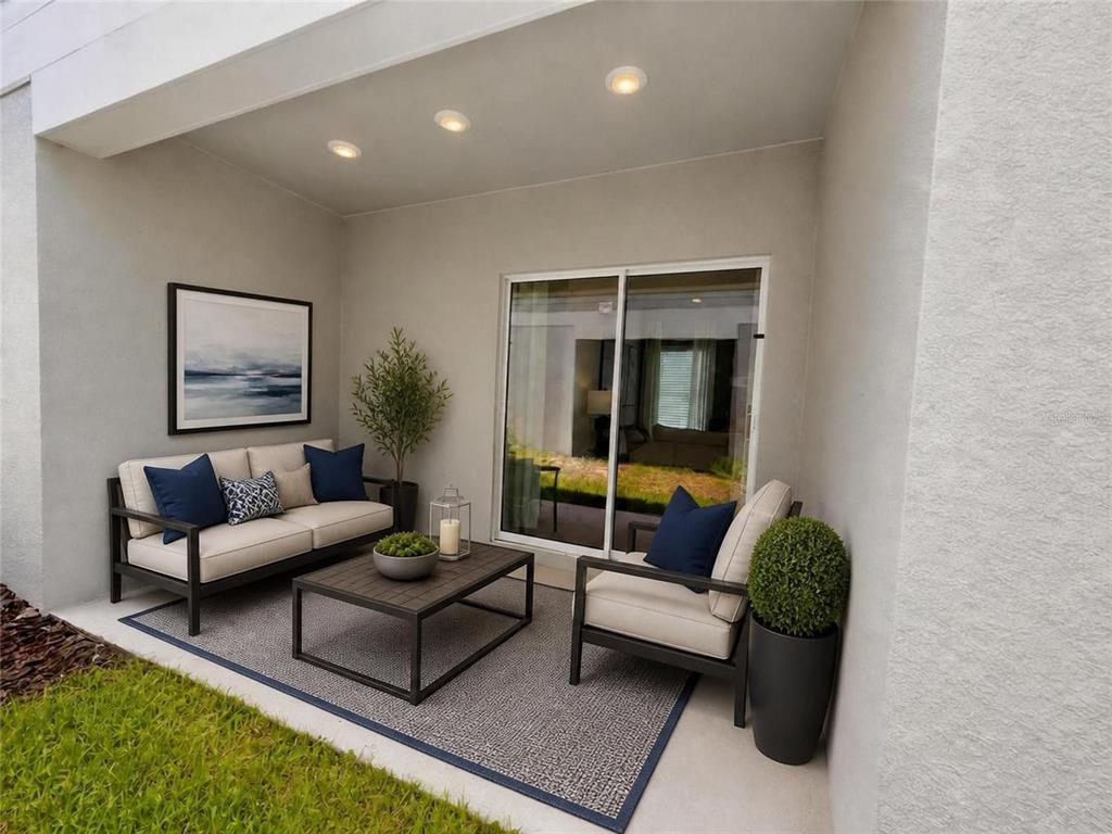 A covered patio features outdoor furniture, a rug, and a potted plant near sliding doors — 6571 EASTWOOD CROSS DRIVE, ORLANDO, FL
