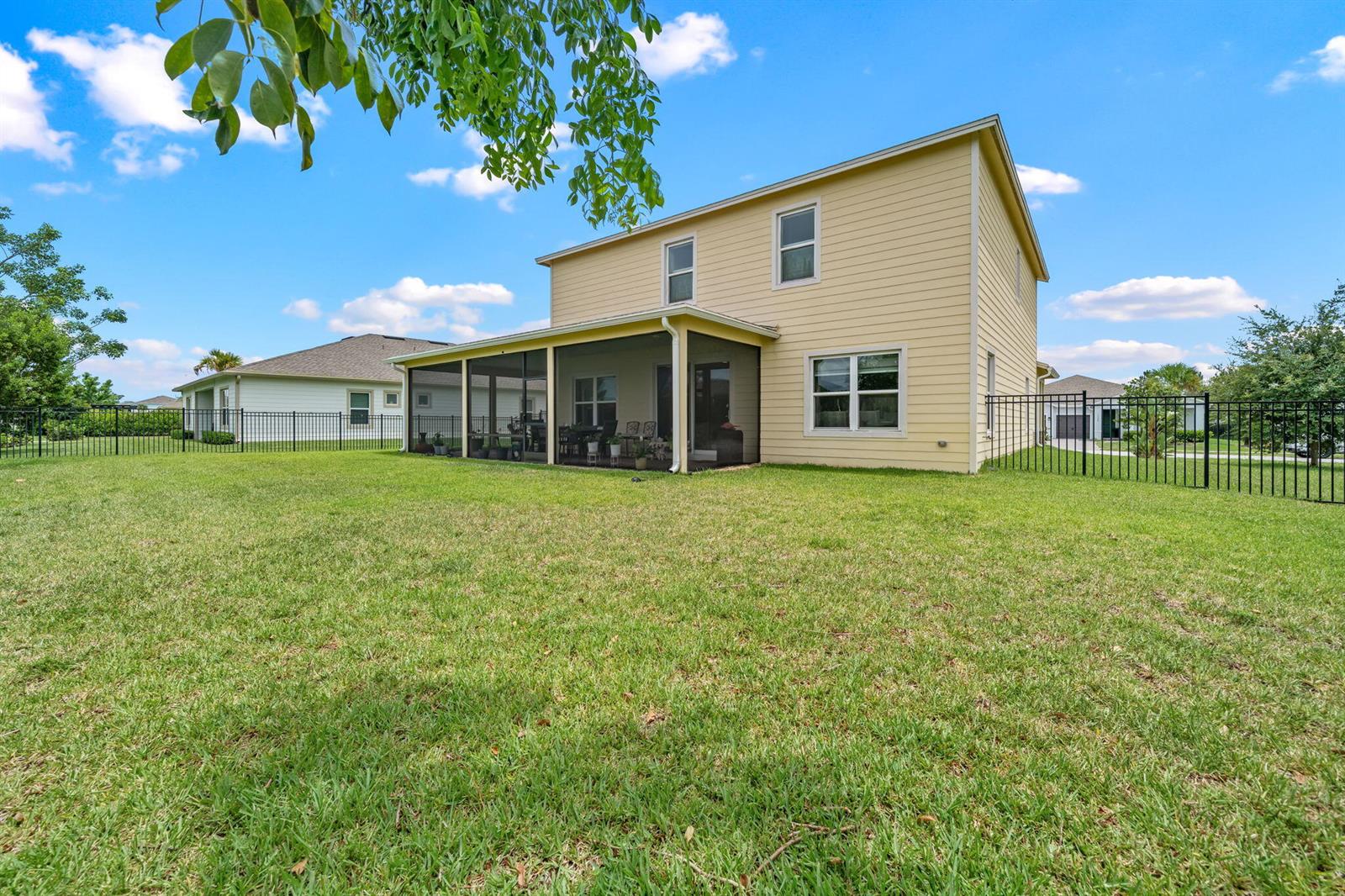 A two-story yellow house features a screened-in patio and a fenced backyard — 19227 Broad Shore Walk, Loxahatchee FL 33470, LOXAHATCHEE, FL