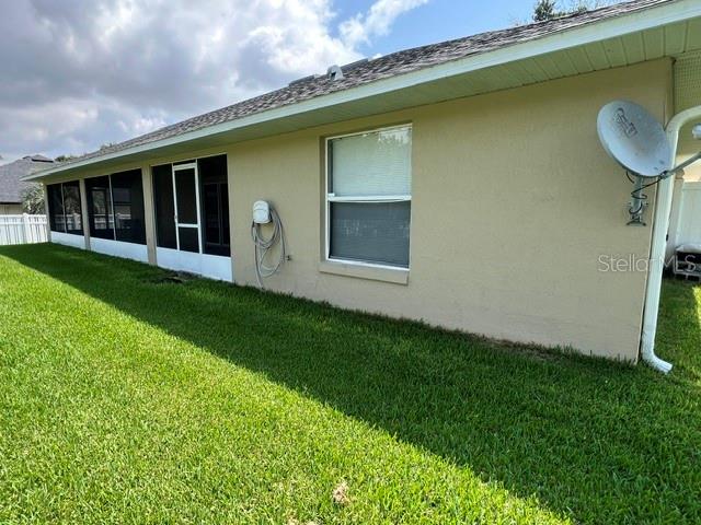 The exterior of a beige house features a screened-in porch and a satellite dish — 1206 BRENTWOOD DRIVE, CLERMONT, FL