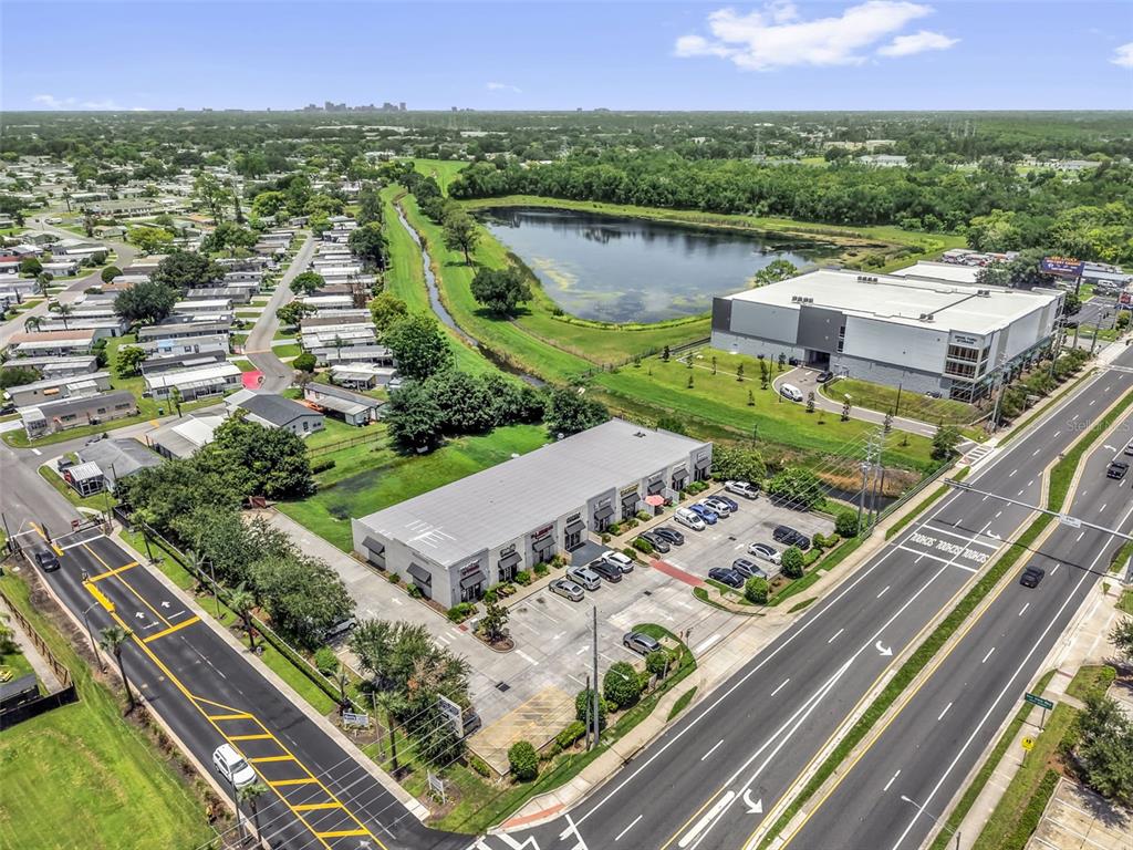 An aerial view shows a commercial building with a parking lot next to a road — 3900 S GOLDEN ROAD UNIT 136, ORLANDO, FL
