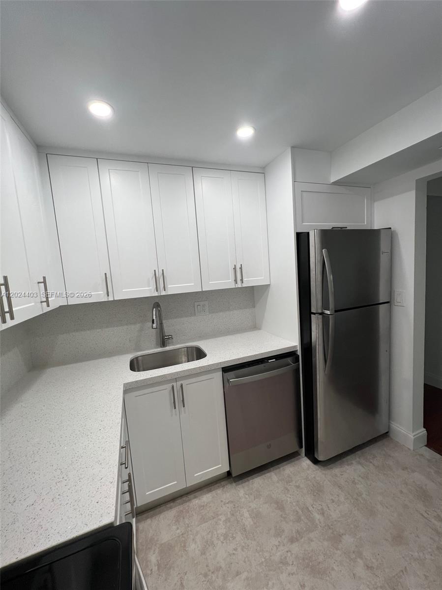 A kitchen features white shaker cabinets, speckled quartz countertops, and stainless steel appliances — 10415 N Kendall Dr # B113, Miami FL 33176, MIAMI, FL