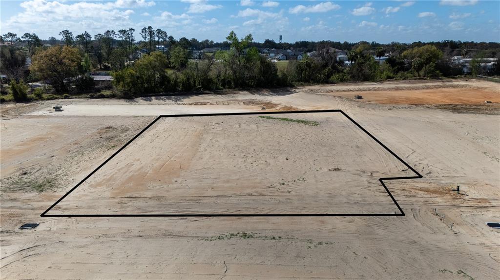 An aerial view shows a cleared, vacant residential lot outlined in black — 32840 DUNNE ROAD, SAN ANTONIO, FL