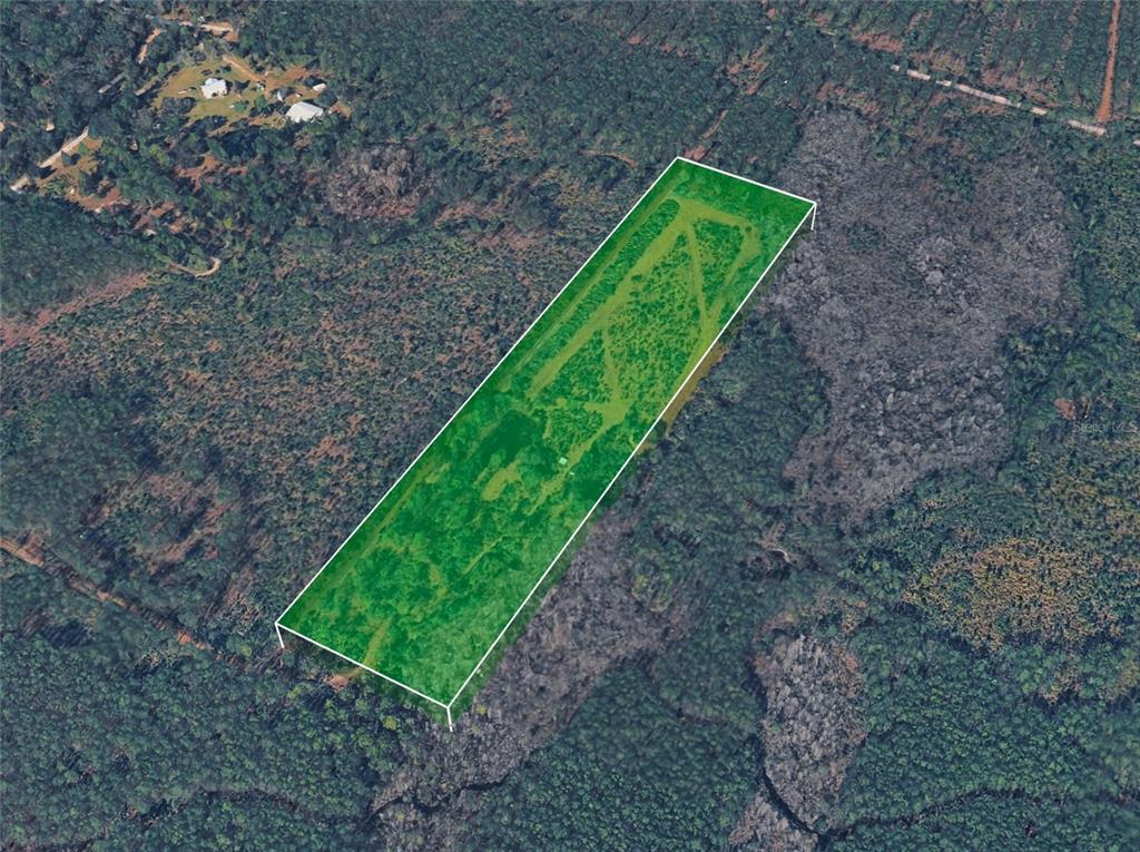 An aerial view shows a rectangular plot of land highlighted in green amidst wooded terrain — BOY SCOUT CAMP ROAD, NEW SMYRNA BEACH, FL