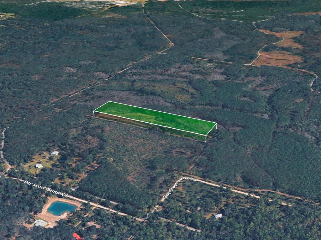 An aerial view shows a rectangular parcel of land highlighted in green near a road — BOY SCOUT CAMP ROAD, NEW SMYRNA BEACH, FL