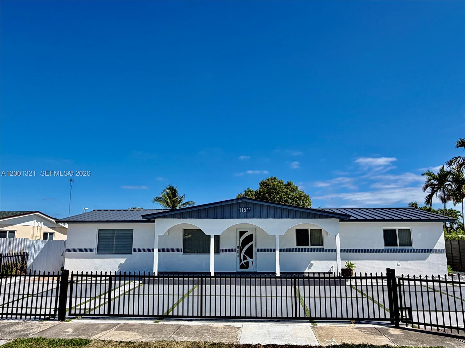 A single-story white house with a metal roof and a black metal front fence — 11511 SW 180th St, Miami FL 33157, MIAMI, FL