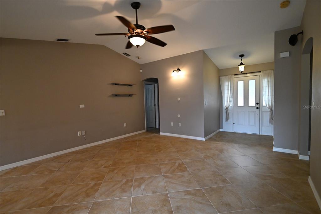 A kitchen features dark wood cabinets, stainless steel appliances, granite countertops, and a tiled backsplash — 2043 OLD TRENTON LANE, SARASOTA, FL