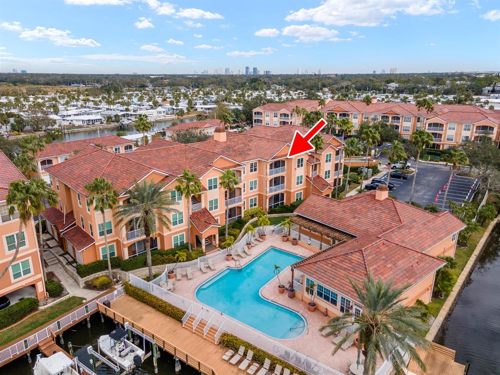 An aerial view shows a multi-story apartment building with a swimming pool and boat docks — 5000 CULBREATH KEY WAY UNIT 4303, TAMPA, FL