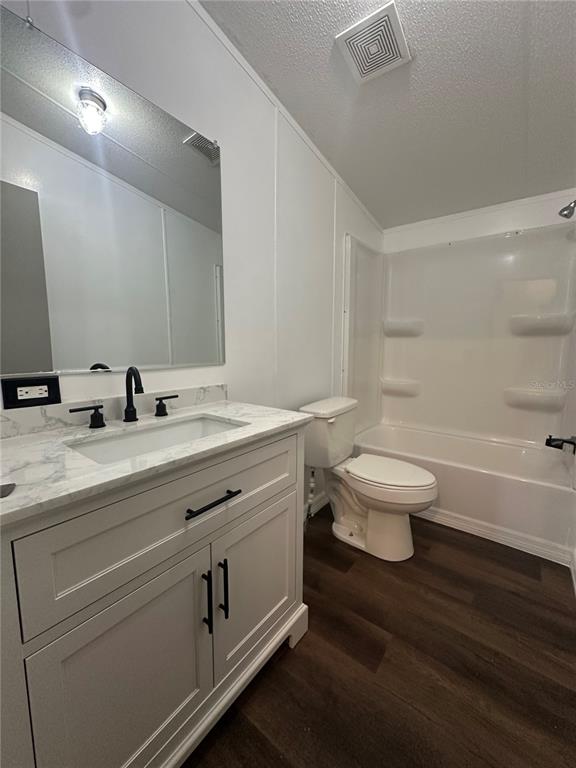 A single-story manufactured home sits on a wooded lot with a paved driveway — 2363 GERBER DAIRY ROAD, WINTER HAVEN, FL