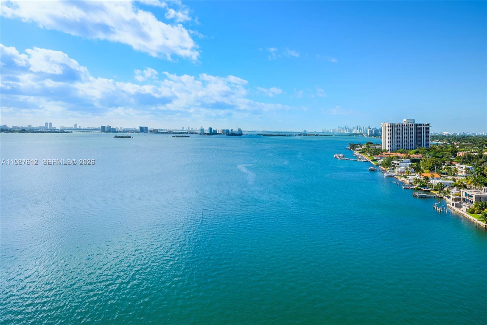An aerial view shows a large body of water bordered by a coastal residential area — 11111 Biscayne Blvd # 19D, Miami FL 33181, MIAMI, FL