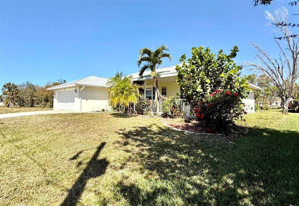 A single-story house with a white exterior, a garage, and a landscaped front yard — 95 WHITE MARSH LANE, ROTONDA WEST, FL