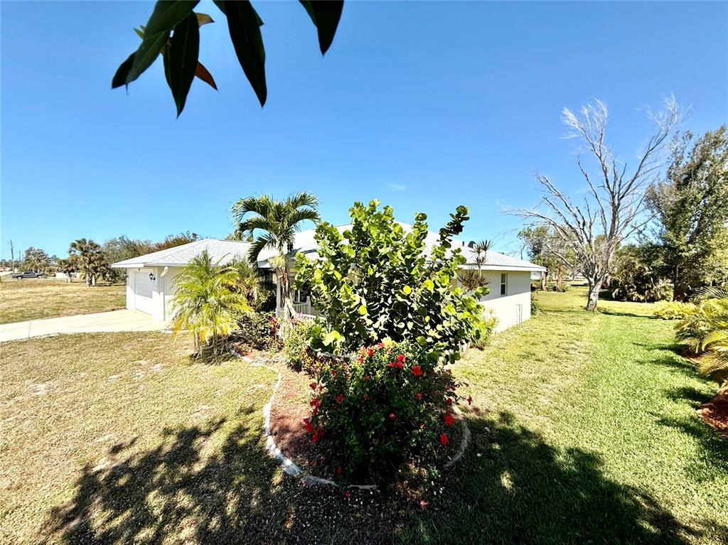A single-story house with a white exterior, a garage, and landscaping in the front yard — 95 WHITE MARSH LANE, ROTONDA WEST, FL