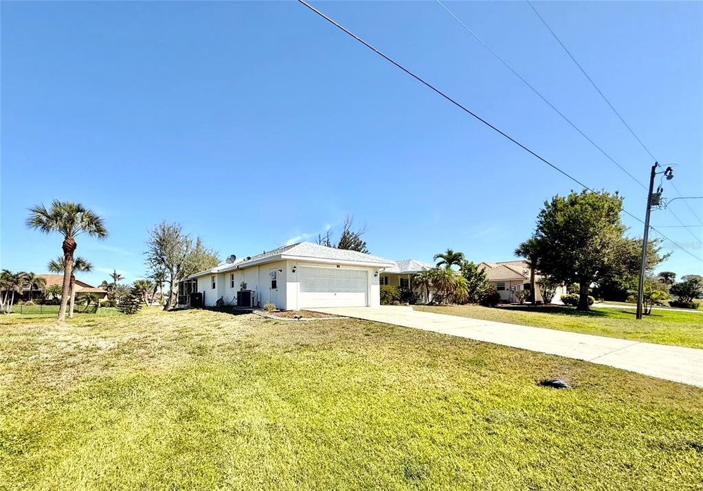 A white single-story house with a two-car garage sits on a large grassy lot — 95 WHITE MARSH LANE, ROTONDA WEST, FL