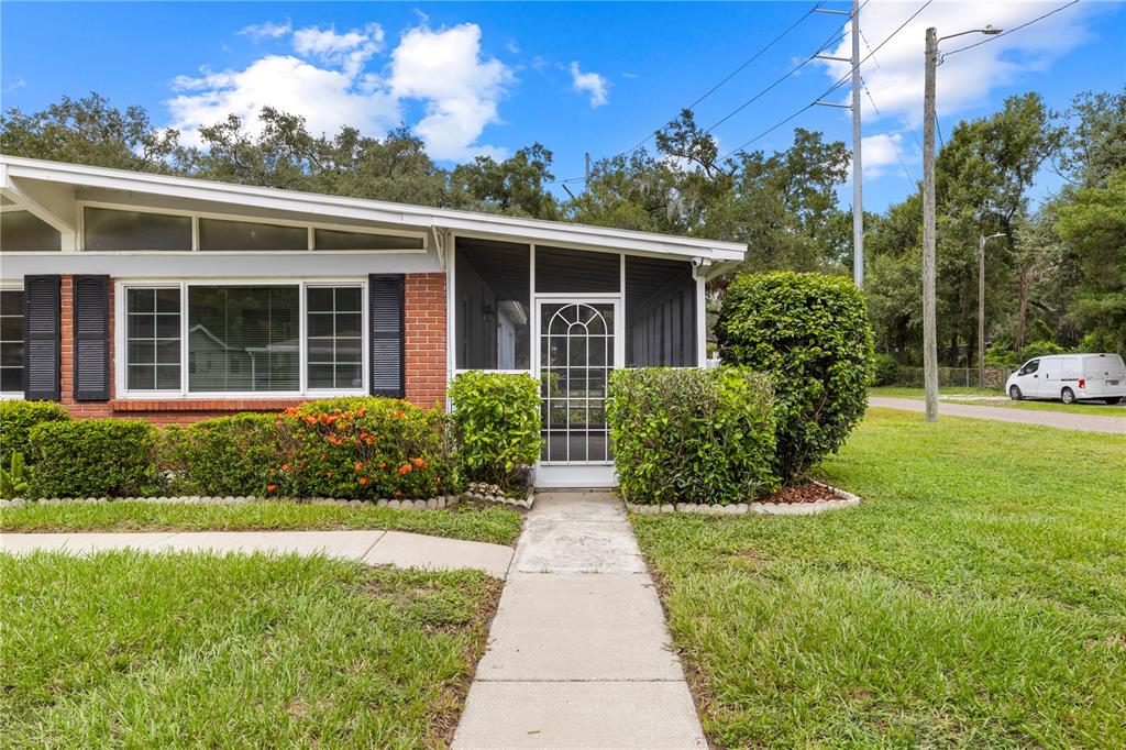 A single-story house with a brick facade, a screened-in porch, and a concrete walkway — 3622 E LAMBRIGHT STREET, TAMPA, FL