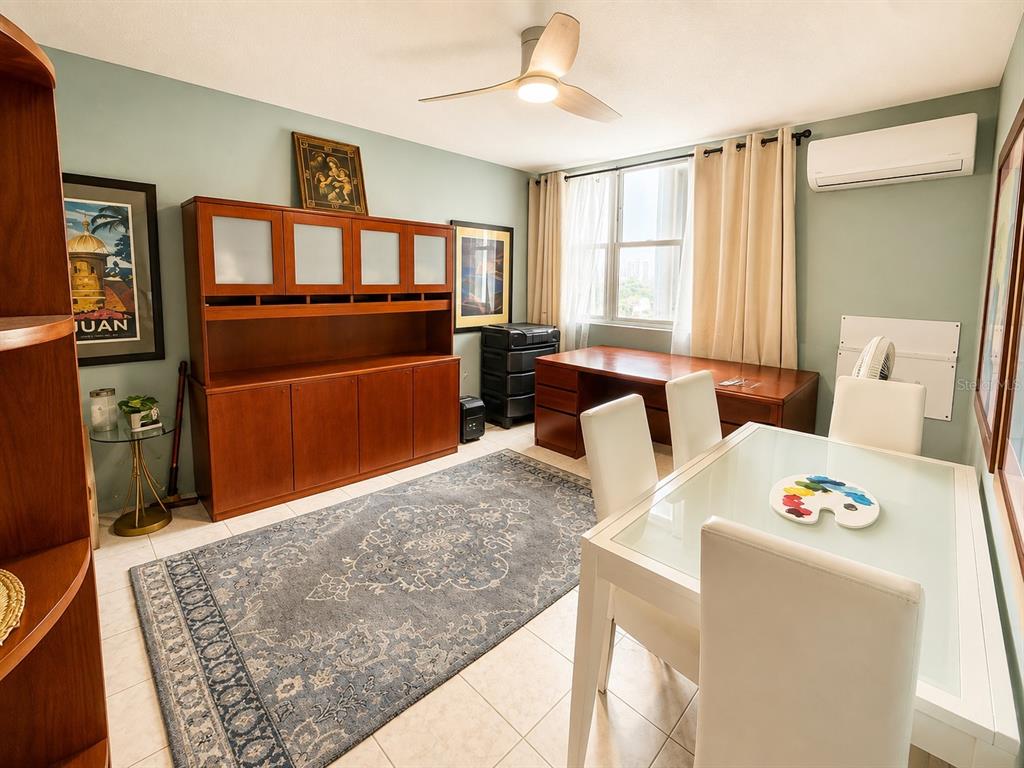 A dining room features a glass-topped table, white chairs, a large wooden hutch, and rug — 1035 AVE. ASHFORD UNIT 407, SAN JUAN, PR