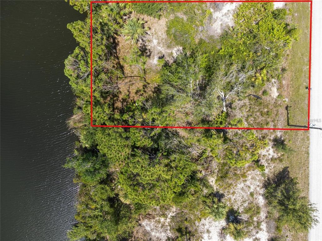 An aerial view shows a rectangular plot of land bordering a body of water — 9602 GAZANIA DRIVE, PORT CHARLOTTE, FL