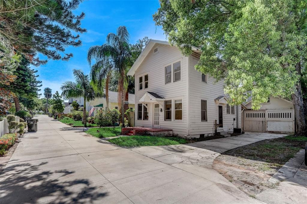 A two-story white house with a front porch and detached garage sits on a paved street — 200 & 200 1/2 HIBISCUS COURT, ORLANDO, FL
