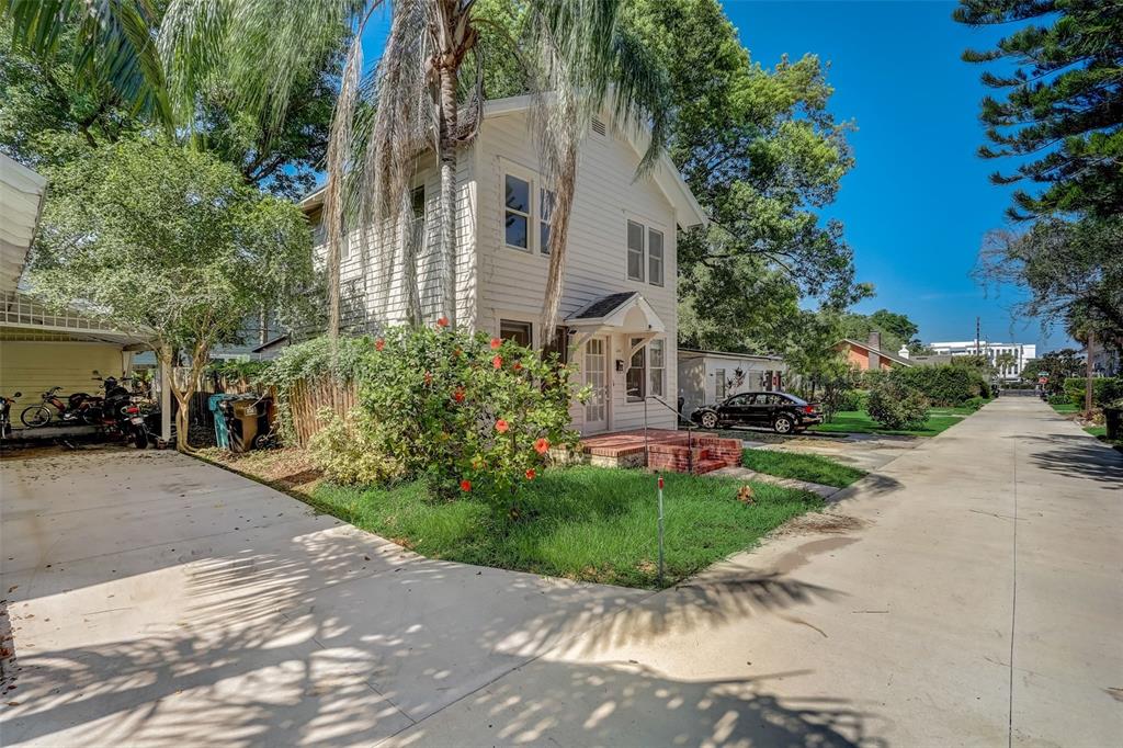 A two-story white house with a front porch and a paved driveway on a sunny day — 200 & 200 1/2 HIBISCUS COURT, ORLANDO, FL
