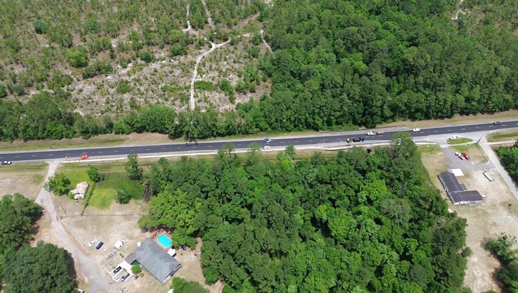 An aerial view shows a house with a pool, surrounding woods, and a nearby highway — MARSHALL LANE, GREEN COVE SPRINGS, FL