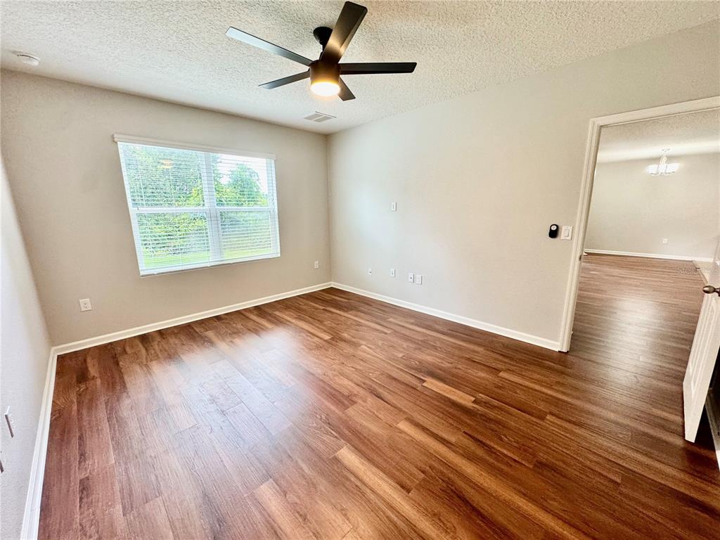 An empty bedroom features light-colored walls, a ceiling fan, and wood-look flooring — 4340 PAGOSA SPRINGS CIRCLE, MELBOURNE, FL