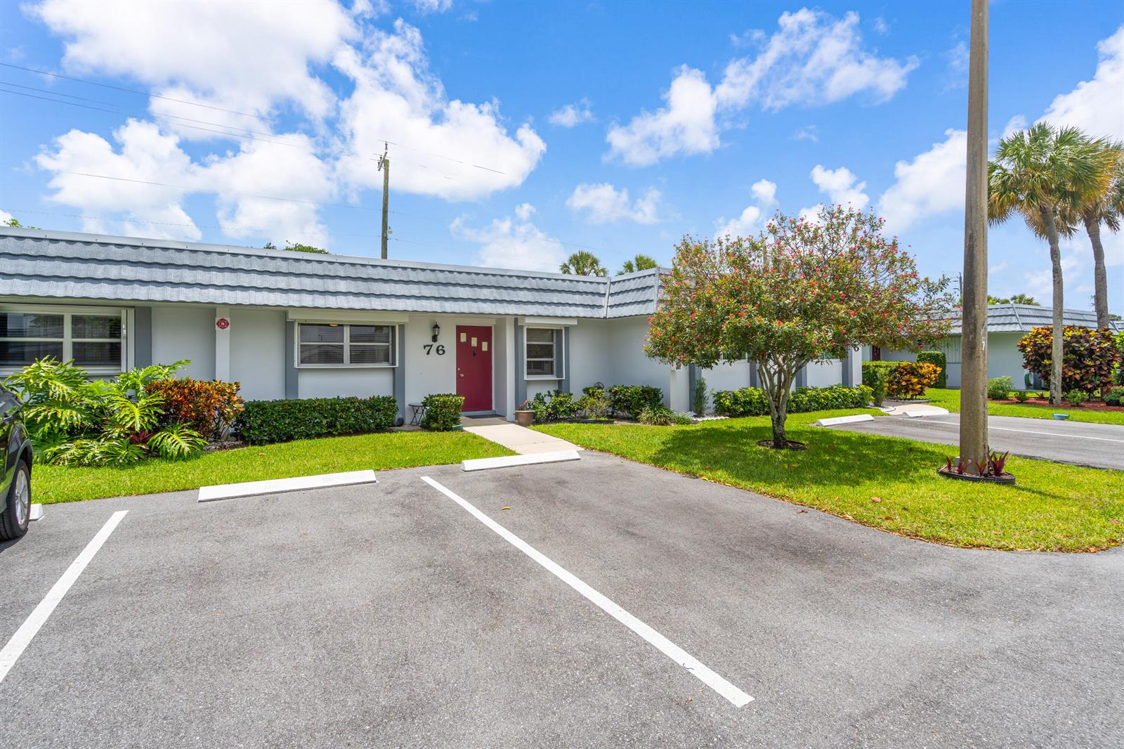 A single-story residential building with a red front door and a paved parking area — 2886 Fernley Drive E # 76, West Palm Beach FL 33415, WEST PALM BEACH, FL