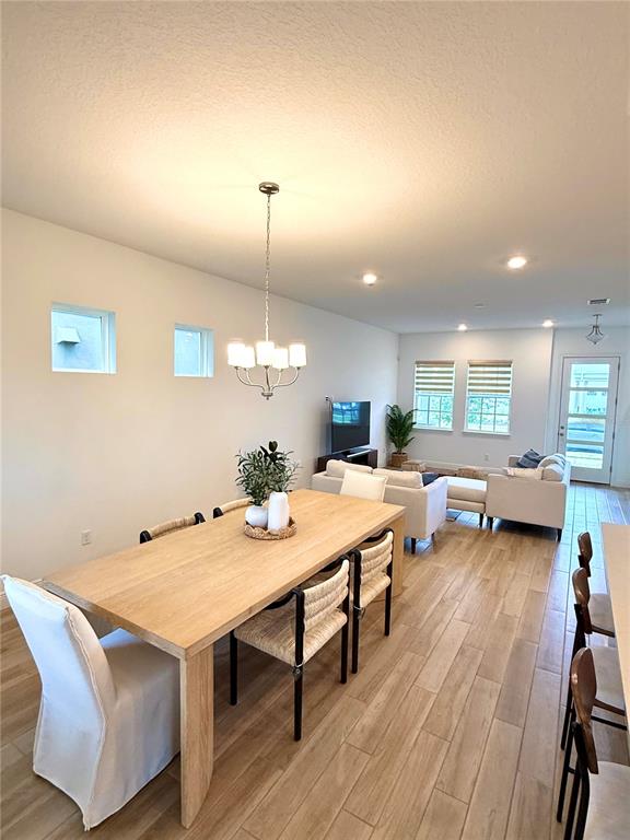 A dining area with a wooden table and chairs opens into a living room — 9922 RODBELL STREET, ORLANDO, FL