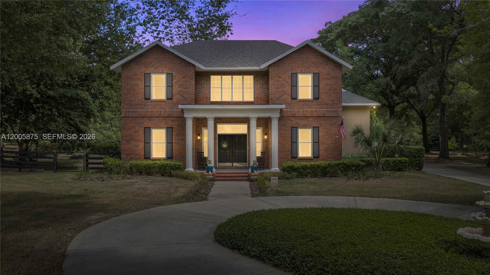 A two-story brick house features a columned front porch and a circular driveway — 9175 SE 7th Avenue Rd, Ocala FL 34480, OCALA, FL