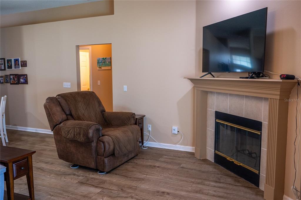 A kitchen sink with a stainless steel faucet overlooks a living room with a fireplace — 6 BRADLEY PLACE, PALM COAST, FL