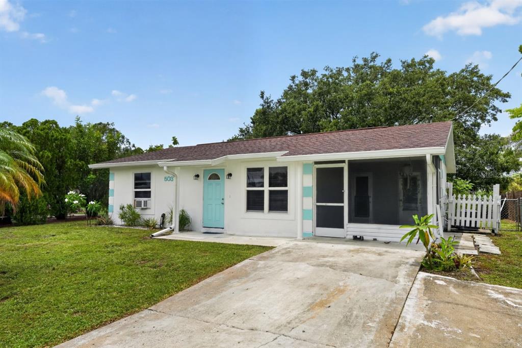 A single-story white house with a light blue door and a screened-in front porch — 5037 BULLARD STREET, NORTH PORT, FL