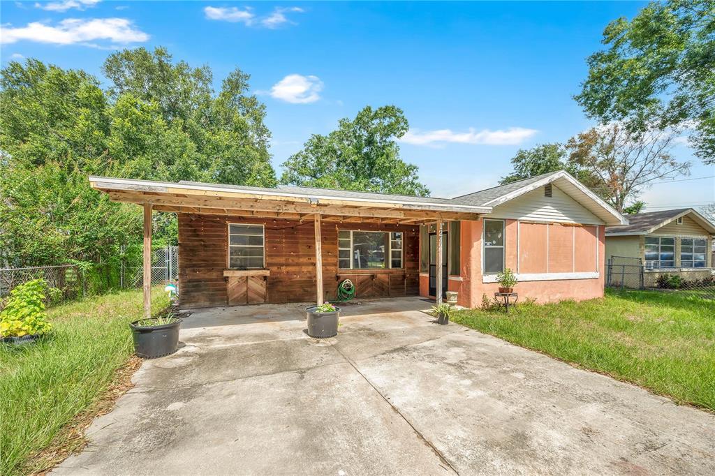 A single-story house with a wooden facade, a carport, and a concrete driveway — 124 CENTER STREET, WINTER HAVEN, FL