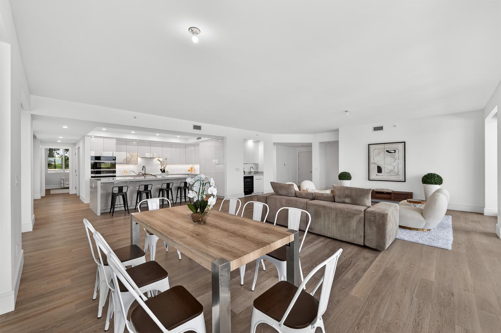 An open-concept living and dining area features a modern kitchen with a large island — 1 S Coastal Way # 201, Jupiter FL 33477, JUPITER, FL