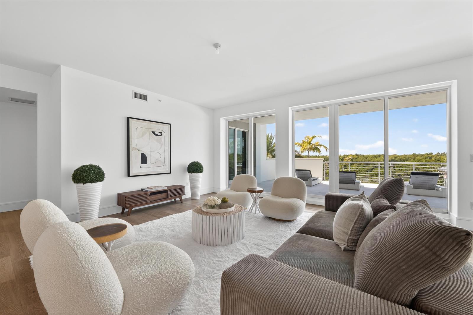 A modern living room features white walls, a textured rug, and a balcony with views — 1 S Coastal Way # 201, Jupiter FL 33477, JUPITER, FL