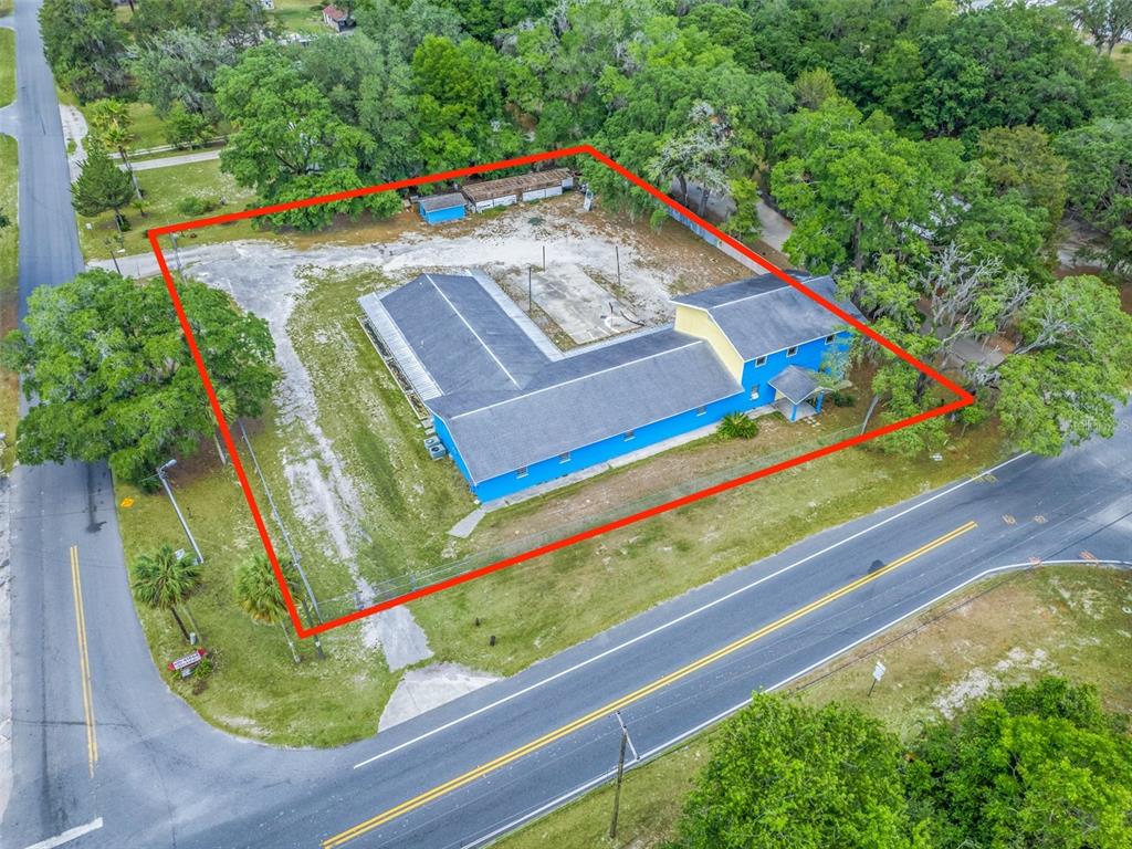 An aerial view shows a blue L-shaped building on a large lot with sparse vegetation — 9475 SE 35TH COURT, OCALA, FL