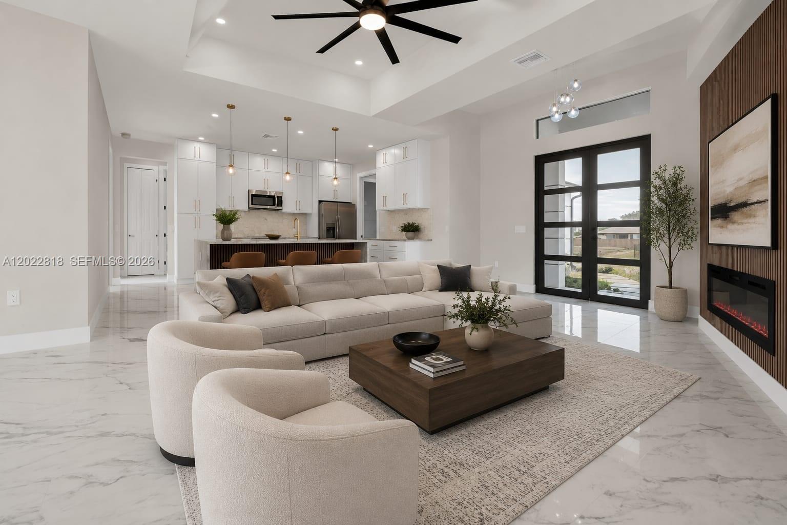 This modern open-concept living room features a white sectional, two armchairs, and a fireplace — 1413 NE 4TH PL, Cape Coral FL 33909, CAPE CORAL, FL