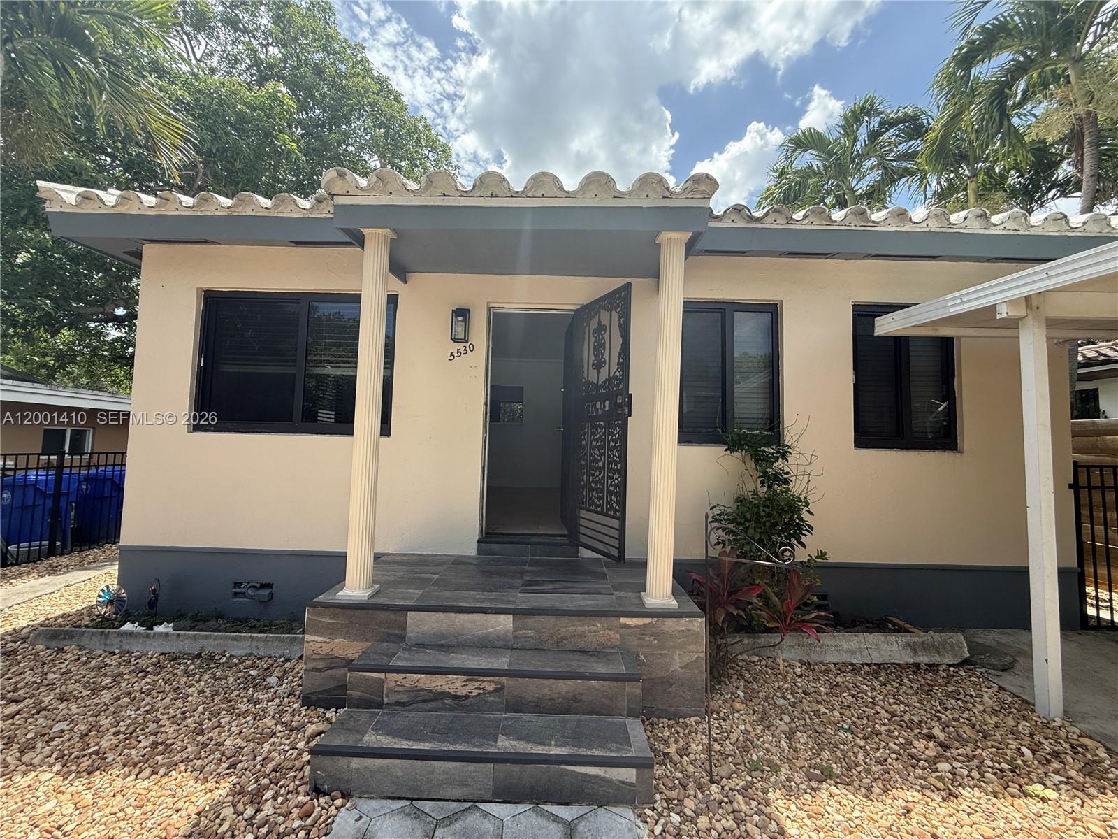 A single-story house features a tiled front porch with two columns and a decorative door — 5530 NW Miami Ct, Miami FL 33127, MIAMI, FL