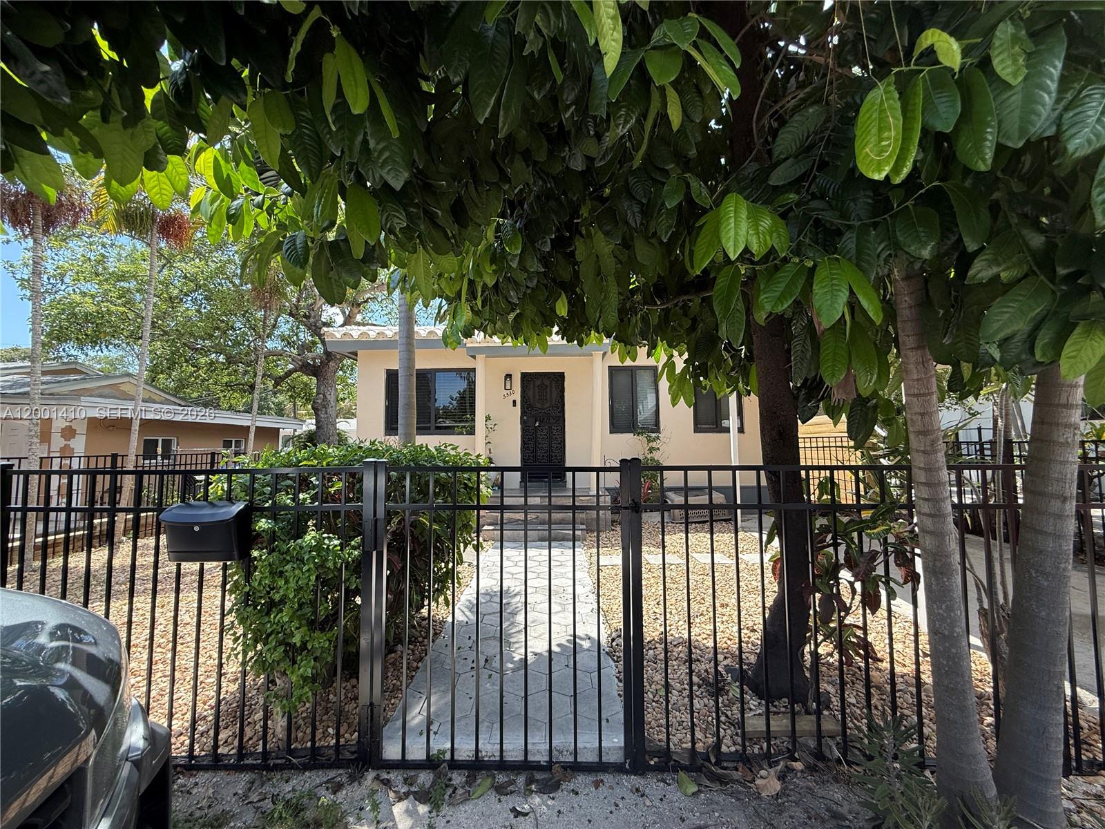 A single-story house with a black metal fence and a stone walkway in the front — 5530 NW Miami Ct, Miami FL 33127, MIAMI, FL