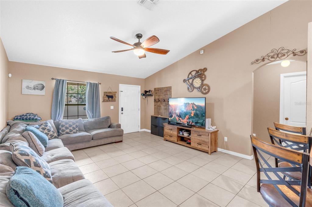 A living room features a large gray sectional sofa, tile flooring, and a television console — 1845 6TH AVENUE, DELAND, FL