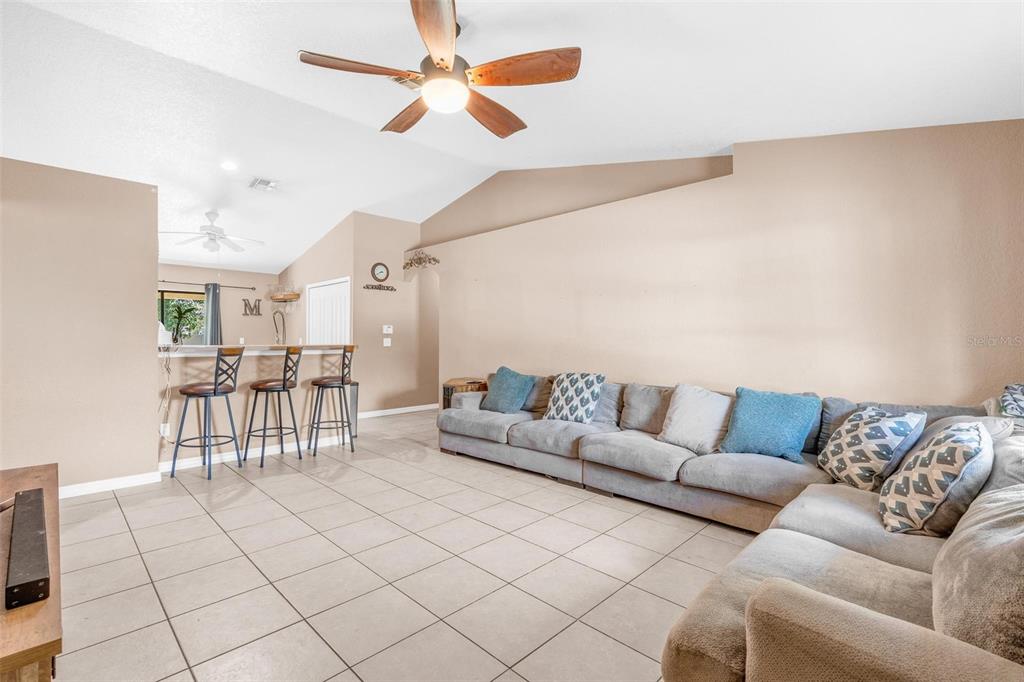 A living room features a large sectional sofa, tiled floors, and a breakfast bar area — 1845 6TH AVENUE, DELAND, FL