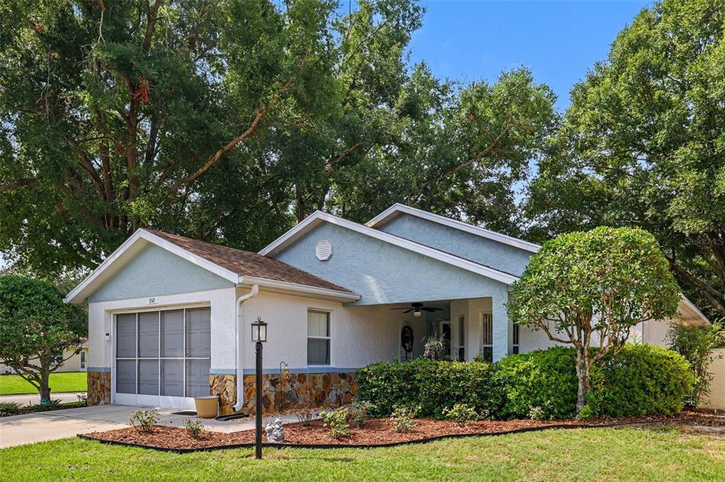 A single-story house with a light blue exterior, stone accents, and a covered front porch — 9141 SW 91ST CIRCLE, OCALA, FL