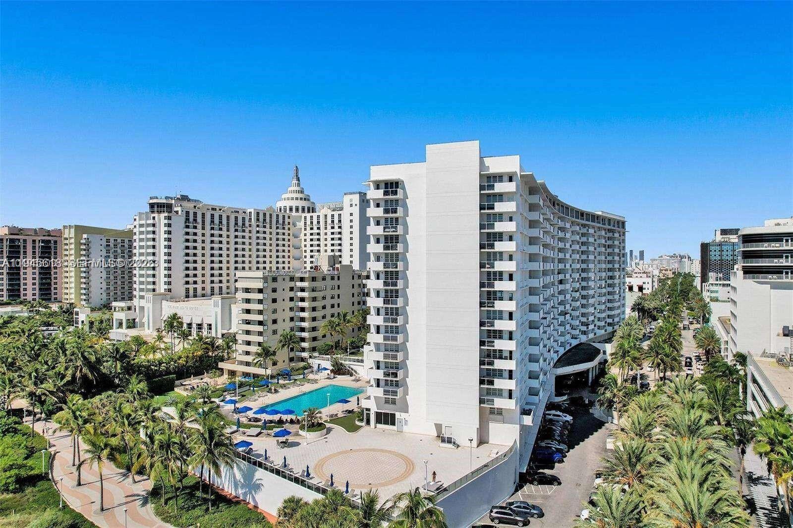 An aerial view shows a large white residential building with a pool and palm trees — 100 Lincoln Rd # 503, Miami Beach FL 33139, MIAMI BEACH, FL