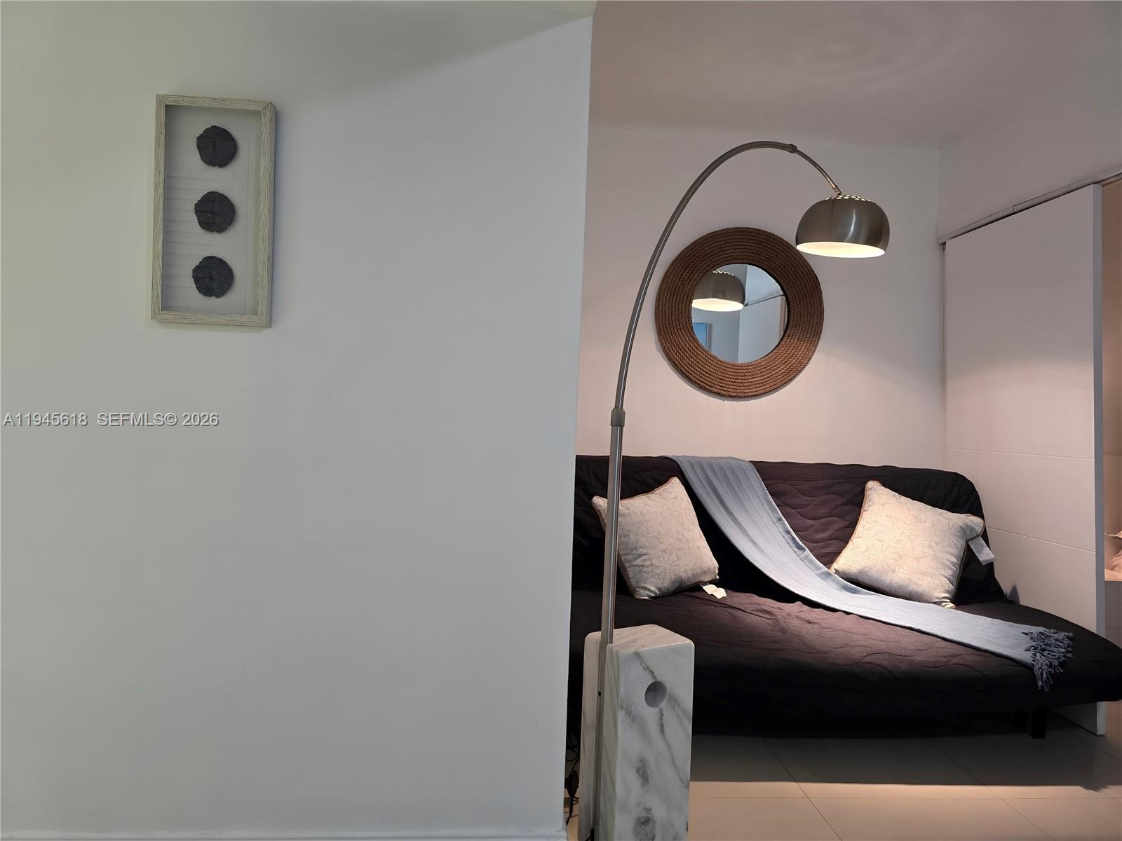 A living area features a dark sofa, a marble-based floor lamp, and wall decor — 100 Lincoln Rd # 503, Miami Beach FL 33139, MIAMI BEACH, FL