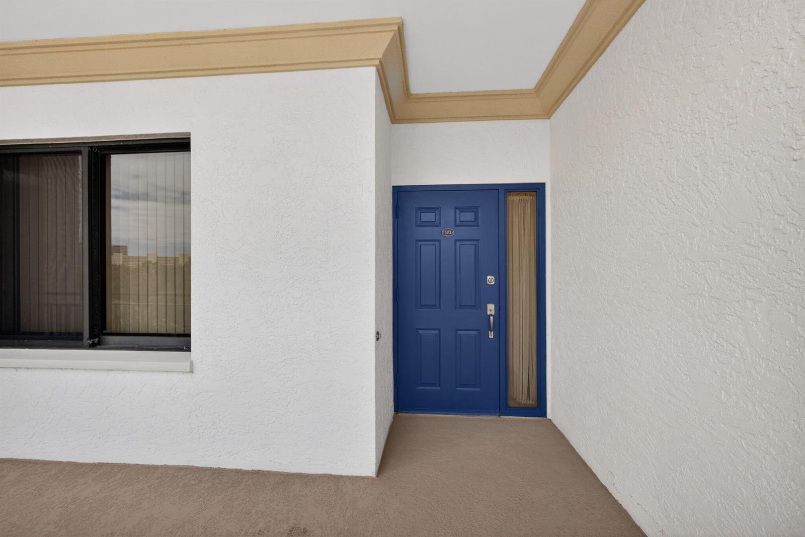 A blue front door with a side window is set into a white stucco wall — 370 Golfview Road # 503, North Palm Beach FL 33408, NORTH PALM BEACH, FL