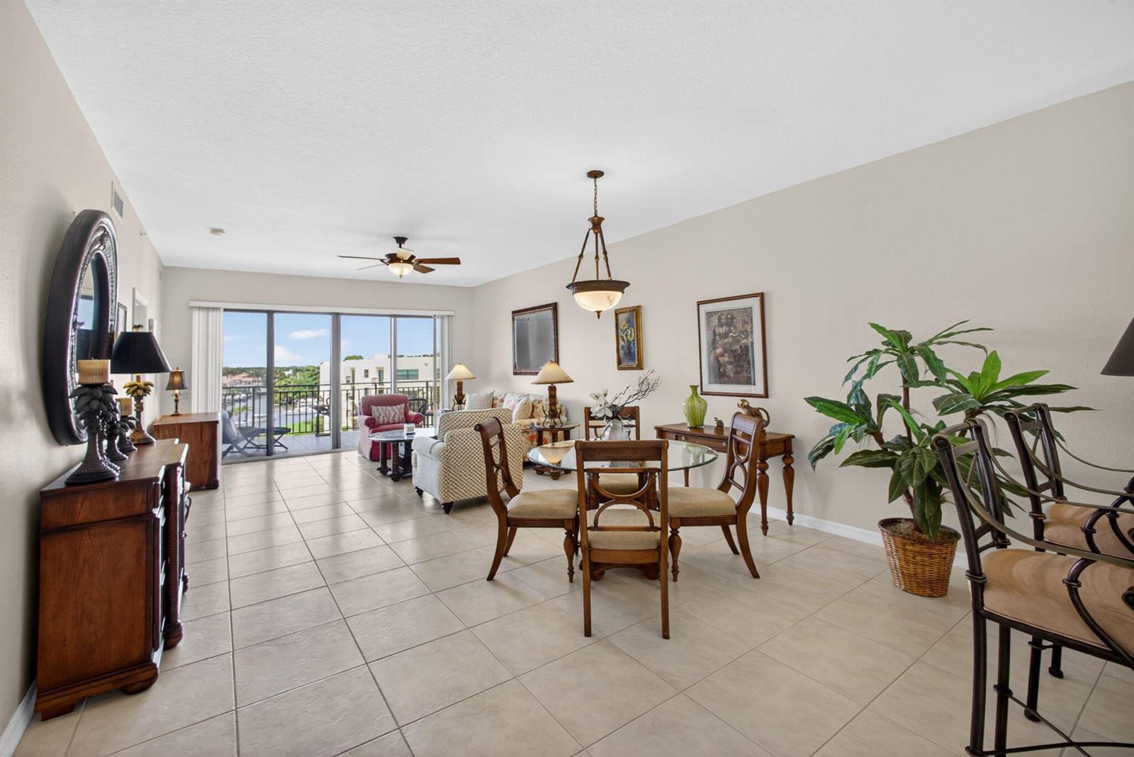An open-concept living and dining area with tile floors, a glass table, and balcony access — 370 Golfview Road # 503, North Palm Beach FL 33408, NORTH PALM BEACH, FL