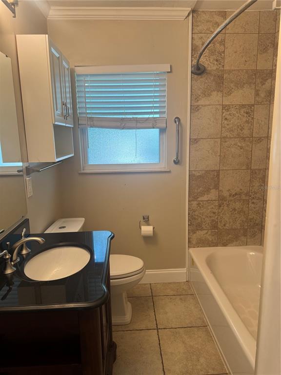 A bathroom features a dark vanity, a toilet, and a tiled shower-tub combination — 1701 53RD STREET S, GULFPORT, FL