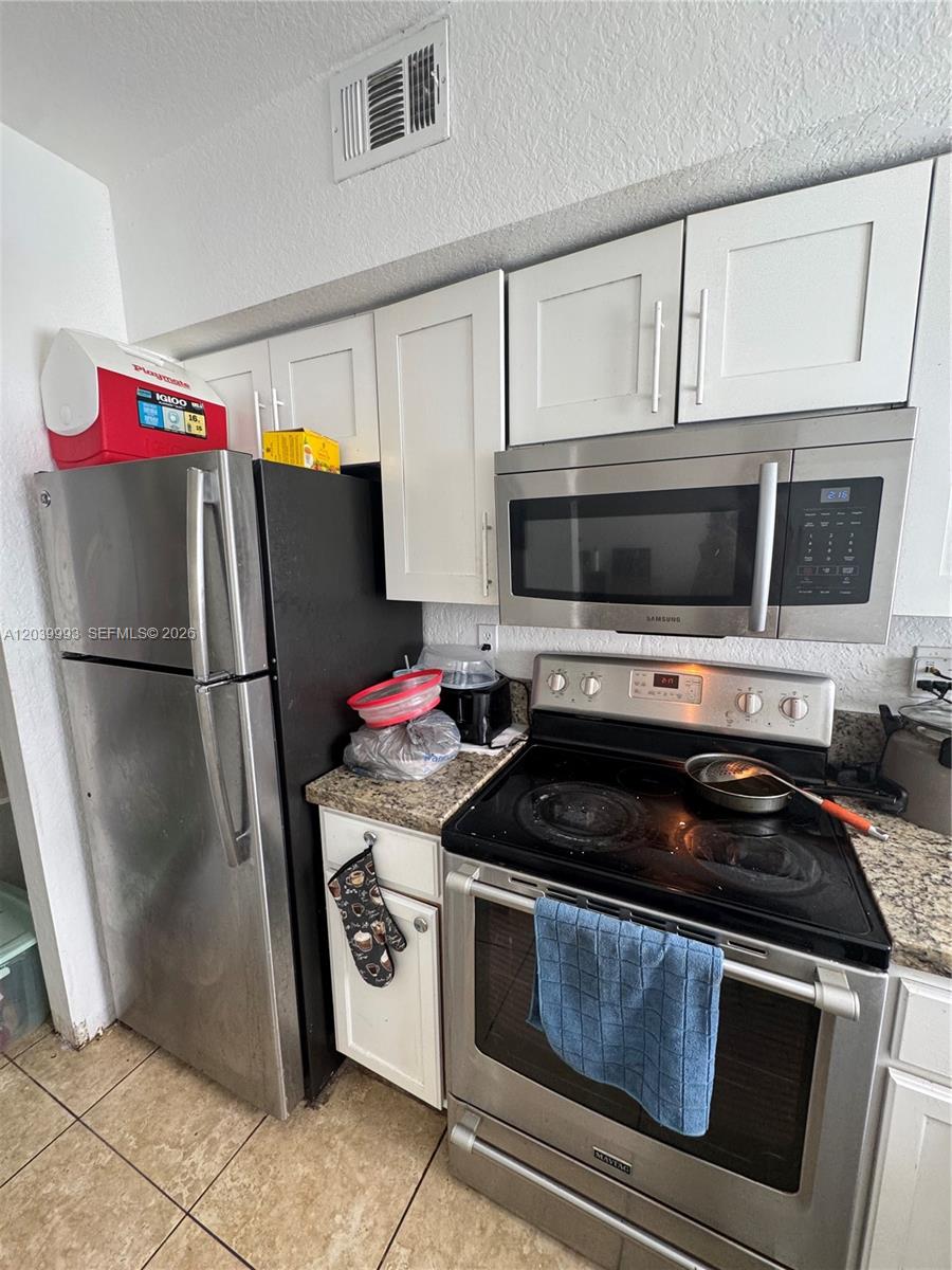 A kitchen features stainless steel appliances, white cabinets, and granite countertops — 8456 NW 4th Ct # 8456, Miami FL 33150, MIAMI, FL